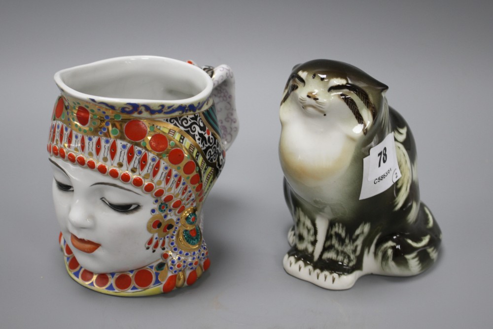 A Russian ceramic figure of a seated cat, height 15cm, and a character jug depicting a womans head with elaborate head-dress, height 1